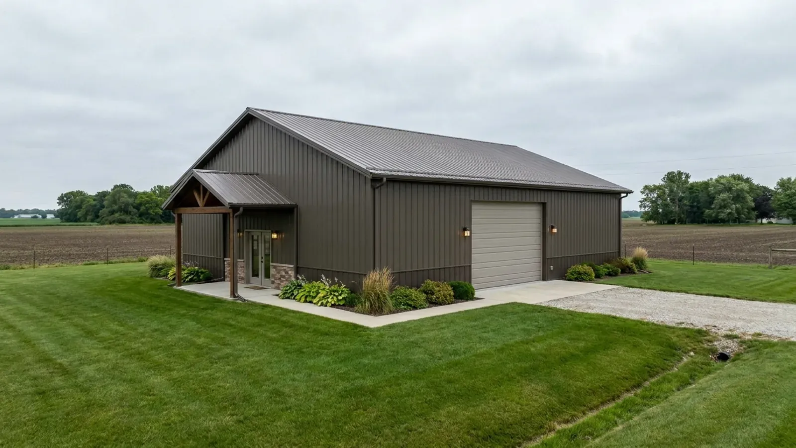 A completed 40x60 barndominium showing a residential entry on one end and a wide shop door on the other under one continuous roof.